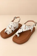 Sandalias planas de cuero color dorado champagne, con capellada de diseño tejido, tira separadora de dedos y tira ajustable en el talón con hebilla metálica.