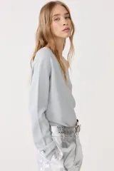 Top de punto color celeste con lurex, de un solo hombro y manga larga.