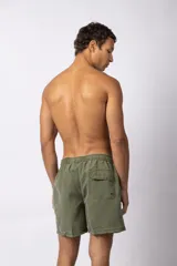 Short de baño de corte relajado en color gris azulado con efecto lavado. Cuenta con cintura elastizada con cordón ajustable, bolsillos laterales y una pequeña etiqueta decorativa en el ruedo.