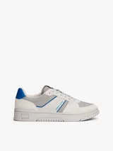 Zapatillas Tommy Jeans de corte bajo, confeccionadas en ante con paneles de malla y cuero sintético. Presentan un diseño en tonos gris y blanco con detalles en azul vibrante, cordones moteados y suela cupsole de goma con logo en bajo relieve.