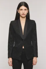 Blazer slim negro con tejido sastrero con lúrex, profundo escote en V, solapa tipo smoking de satén, un botón frontal, bolsillos ojal y tajo en la espalda.