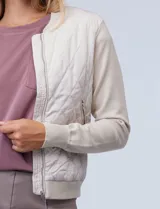 Campera bomber color beige, marca Elie Tahari. El frente es capitoneado con diseño de rombos, la espalda y las mangas son tejidas.