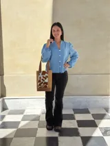 Bolso tipo matera confeccionado en cuero, con diseño combinado que presenta laterales con textura de cocodrilo y panel central con estampado animal print de vaca. Cuenta con asas largas para llevar al hombro y base reforzada.