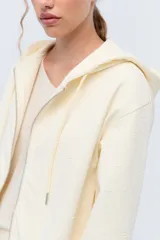 Campera deportiva con capucha confeccionada en tela elastizada texturada con diseño de flores.