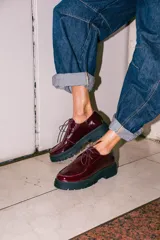 Zapatos tipo wallabee de cuero metalizado en tono peltre, con cordones negros y suela track de goma negra con plataforma.