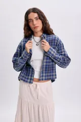 Camisa de manga larga con estampado a cuadros en tonos azules, cuello camisero y cierre frontal con botones.