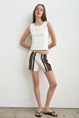 Short color crudo de tiro bajo, con pretina elástica y detalles laterales en marrón y verde militar.