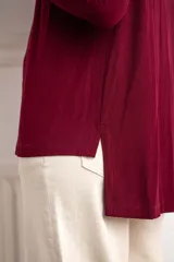 Remerón bordeaux de viscosa con elastano, corte oversize y mangas largas.