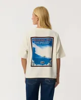 Remera Rip Curl de manga corta, color beige, con diseño boxy y estampado gráfico en la espalda de la competencia de surf Rip Curl Cup en Sunset Beach, Hawaii.