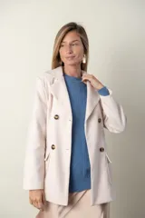 Blazer verde con corte clásico, doble botonadura y bolsillos con solapa.