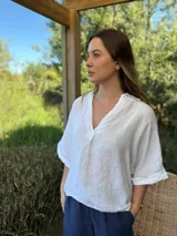 Blusa azul marino de lino, con cuello camisero que forma un escote en V, mangas cortas dobladas y calce holgado.