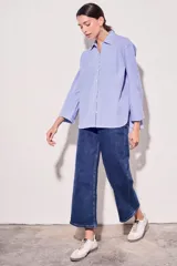 Camisa celeste con rayas verticales blancas, de corte clásico, con cuello camisero y mangas largas.
