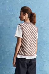 Chaleco tejido de punto con diseño de rayas diagonales en color marrón y beige, cuello polo y escote en V profundo.