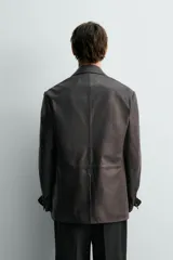 Blazer relaxed fit de cuero marrón oscuro, con cuello de solapa de muesca, cierre de un botón, bolsillos con solapa en la cadera y abertura central en la espalda.