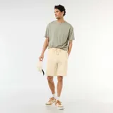 Bermuda de felpa ligera color amarillo claro, con cintura elástica y cordón ajustable.