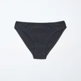 Pack de cinco braguitas de algodón, que incluye dos braguitas negras lisas, dos blancas lisas (una con estampado de lunares pequeños) y una braguita con estampado floral en blanco y negro. Todas tienen detalles de encaje en los bordes.