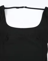 Body negro de mangas largas con espalda descubierta y tiras finas cruzadas.