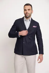 Blazer azul marino de corte slim fit, con solapa de muesca, cierre de doble botonadura, bolsillo de parche en el pecho y bolsillos de parche en la parte inferior.