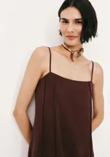 Vestido midi de corte recto y escote cuadrado, con tirantes finos y costuras verticales decorativas a lo largo de la prenda. Color bordó.