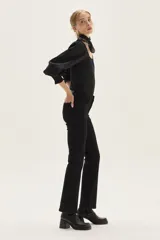 Top de calce ajustado color marrón, con escote cuadrado y mangas largas abullonadas de tela lisa. Los puños de las mangas son elastizados.