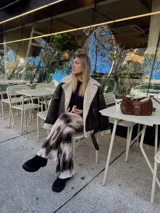 Calza de lycra con estampado abstracto en tonos marrones y blancos, corte ajustado y acampanado en el ruedo.