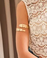 Brazalete dorado con forma de pluma.