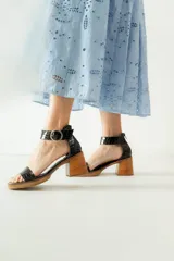 Sandalias de cuero color beige con plataforma y taco cuadrado de madera. Presentan una tira frontal ancha y una tira ajustable en el tobillo con hebilla metálica plateada.