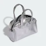 Mini bolso estilo bowling Adidas Adicolor plateado con acabado metalizado, asas de mano y correa desmontable. Presenta el logotipo del Trifolio grabado en la parte frontal.