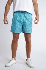 Short de baño con cintura elástica y cordón ajustable, confeccionado en tela ligera de secado rápido. Presenta un estampado botánico integral en tonos amarillos, blancos y azules, con dos bolsillos delanteros y uno posterior.