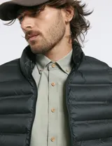 Chaleco acolchado de diseño capitoneado con cierre frontal al tono, cuello alto y ribetes en sisas y ruedo.
