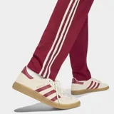 Pantalón deportivo Adidas de la selección de España, color bordó con las icónicas tres tiras blancas laterales. Presenta el escudo de la selección bordado en la pierna derecha y un corte clásico con ajuste cómodo.