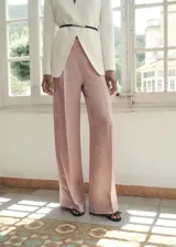 Pantalón wide leg de tiro medio y tejido satinado, con diseño largo y efecto arrugado, y cierre de cremallera en la parte posterior.