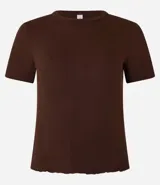 Blusa básica de manga corta, cuello redondo y textura sutil, confeccionada en viscosa con elastano. El bajo de la prenda es ondulado.