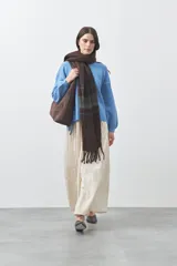 Sweater de tejido liviano con silueta relajada, hombros caídos y mangas largas con puños ajustados. Presenta cuello redondo y lazos ajustables en el bajo.