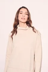 Sweater negro de cuello alto con tajos laterales y detalle de línea plateada en puños y ruedo.