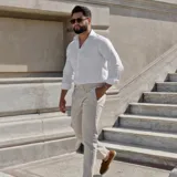 Pantalón de vestir azul marino con pinzas, corte slim fit, bolsillos laterales y traseros.