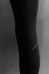 Calzas deportivas largas negras de tejido técnico elástico en cuatro direcciones. Cuentan con cintura elástica ajustable con cordón interior, bolsillos laterales elásticos en la cadera y bolsillo trasero con cierre de cremallera.