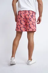 Short de baño con cintura elástica y cordón ajustable, confeccionado en tela ligera de secado rápido. Presenta un estampado botánico integral en tonos amarillos, blancos y azules, con dos bolsillos delanteros y uno posterior.