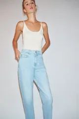 Pantalón jeans Z1975 de tiro alto y diseño mom fit, color azul claro con lavado desgastado, de corte tobillero y cinco bolsillos. Cierre frontal con cremallera y botón metálico.
