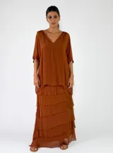 Pollera larga de viscosa color beige con diseño de múltiples capas y volados superpuestos de terminación rústica deshilachada.