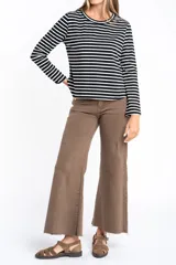 Remera de manga larga con diseño de rayas horizontales en blanco y negro, cuello redondo y corte ajustado al cuerpo.