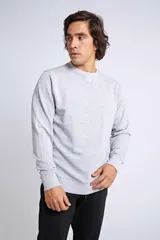Buzo clásico de cuello redondo y manga larga, en color gris melange. Presenta un ajuste regular y un logo bordado con detalle en goma en el pecho.
