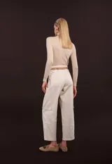 Blusa de punto color beige, de cuello alto y manga larga.