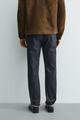 Jeans de corte slim fit en color azul oscuro, con diseño de cinco bolsillos, cierre frontal con cremallera y botón, y tejido ligeramente elástico.