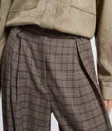 Pantalón de vestir de corte barrel, tiro alto con pliegues delanteros y pierna ancha, confeccionado en tejido con estampado de cuadros en tonos marrones y rojizos.