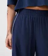 Pantalón deportivo Get Over de corte recto y suelto, confeccionado en microfibra azul marino con cintura elastizada y vivo lateral en color blanco.