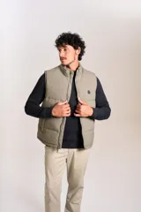 Chaleco puffer de corte regular, color beige, con cuello alto, cierre frontal completo y logo bordado en el pecho.