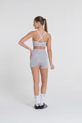 Minishort deportivo gris con cintura alta y recortes laterales blancos.