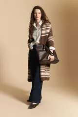 Cardigan largo de tejido de punto con diseño de rayas horizontales en tonos marrones y beige. Presenta una silueta abierta y relajada, ideal para superponer en looks de invierno.