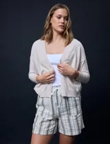 Cárdigan negro tejido en hilado fino con escote en V y un botón.